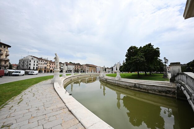 Vista del canal con estatuas en la plaza Prato della Valle y la Basílica de Santa Giustina en Padova Veneto Italia