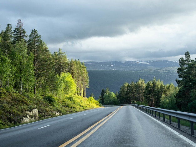 Vista de una carretera de asfalto vacía con líneas amarillas dobles.