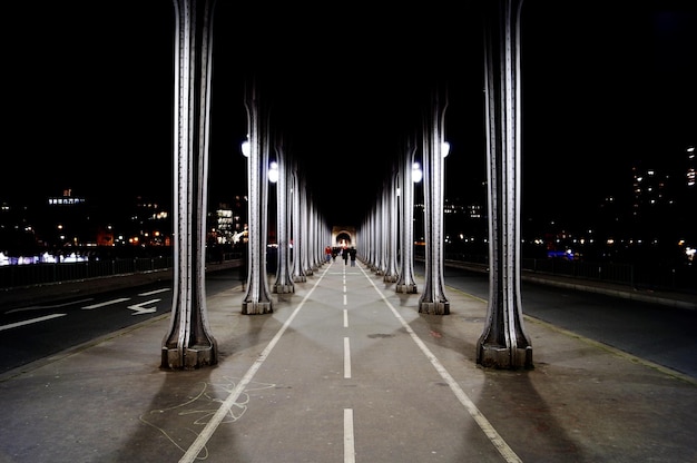 Vista de la carretera iluminada bajo el puente en la ciudad por la noche