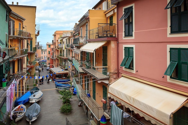 Foto vista de una carretera de manarola pequeños barcos a motor en invierno están pavimentados en la calle debajo de las casas