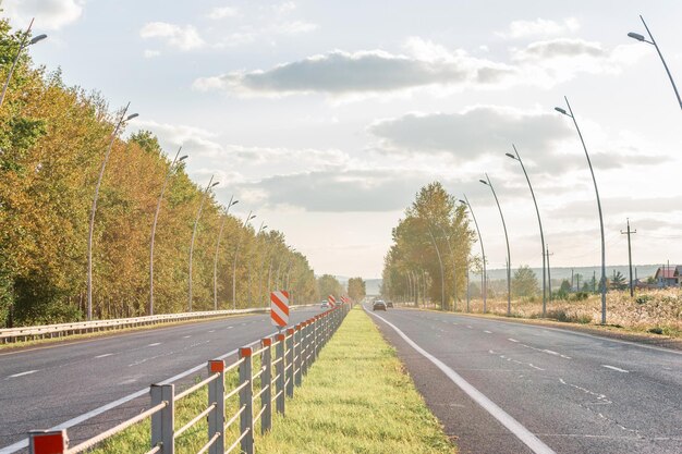 Vista de la carretera rodeada de árboles contra el telón de fondo del sol.