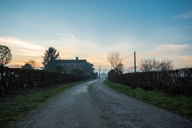 Vista de una carretera sucia genérica en el paisaje rural en temporada de invierno