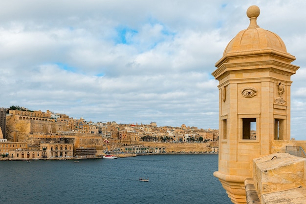 Foto vista del casco antiguo de valletta con torre de vigilancia y jardines gardjola en senglea desde el mar, malta, europa