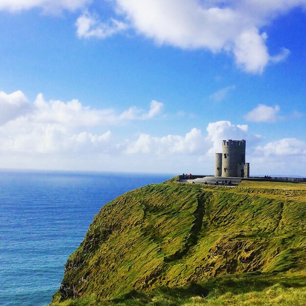 Vista del castillo en los acantilados de moher por el mar contra el cielo