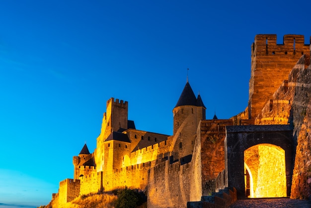 Foto vista del castillo por la noche en la ciudad medieval amurallada de carcassonne (la citãƒâ ©) en francia.