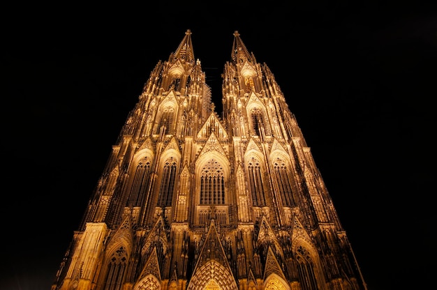 Vista de la catedral iluminada de Colonia contra el cielo en la noche foto de archivo