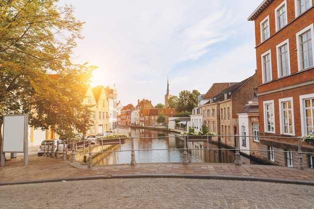 Vista cênica da cidade do canal de Bruges com belas pontes de casas coloridas medievais e reflexões na hora do ouro da noite Bélgica