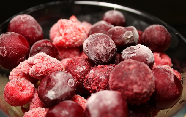 Vista de cerca de bayas de frutas mixtas congeladas en un vaso Foto de stock