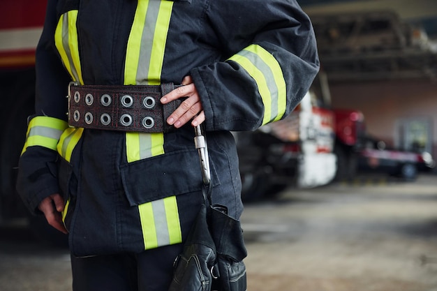 Vista de cerca Bombero femenino en uniforme protector de pie cerca del camión