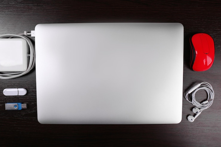Foto vista de cerca de la computadora portátil y el equipo en el lugar de trabajo sobre fondo de madera negra