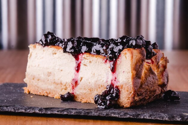 Vista de cerca de un delicioso pastel de queso casero con salsa de arándano