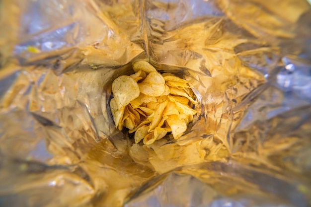 Vista de cerca dentro de una gran bolsa plateada de papas fritas con enfoque selectivo