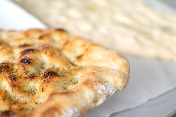 Vista de cerca de Dos masas típicas de Focaccia italiana una cocida y otra blanca levitada juntas