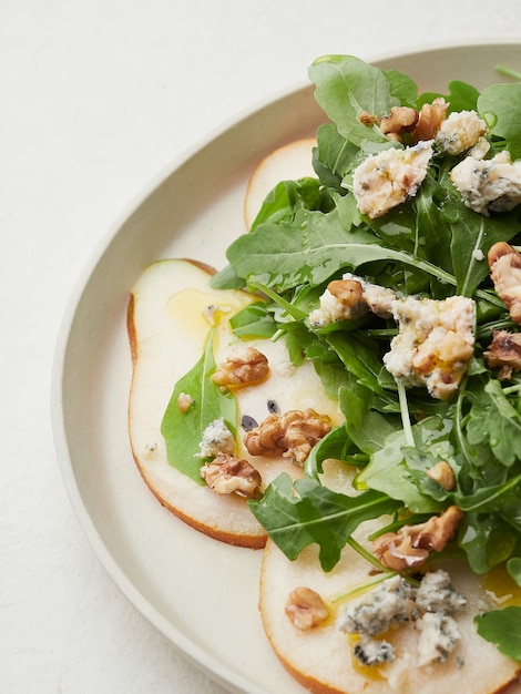 Vista de cerca de ensalada de nueces y queso azul de pera rúcula