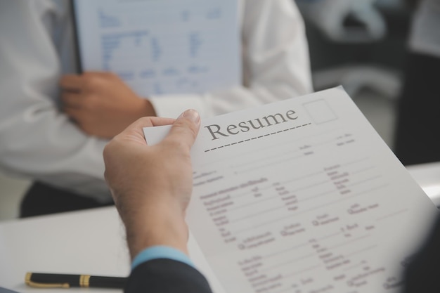 Vista de cerca de la entrevista de trabajo en la oficina centrarse en la redacción de currículums consejos empleador revisando buen currículum de solicitante calificado preparado reclutador considerando la solicitud gerente de recursos humanos tomando decisión de contratación