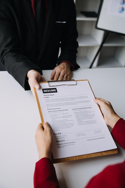 Vista de cerca de la entrevista de trabajo en la oficina, enfoque en la redacción del currículum, consejos para el empleador, revisión del buen currículum vitae del reclutador de candidatos calificado preparado, considerando la aplicación, gerente de recursos humanos, que toma la decisión de contratación