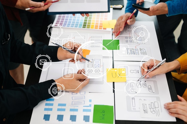 Vista de cerca del equipo de desarrolladores de la interfaz de usuario haciendo una lluvia de ideas sobre su proyecto con un teléfono inteligente portátil y una tableta digital Agencia de desarrollo digital creativaxA