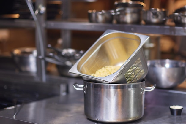 Vista de cerca de fideos de pasta o espaguetis en un recipiente de comida después de hervir en una mesa