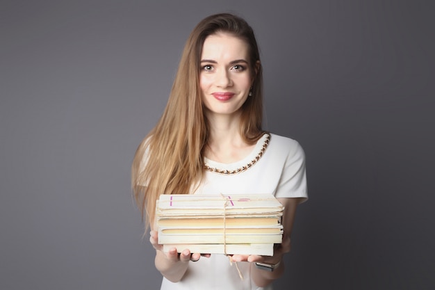 Vista de cerca de hermosa mujer sosteniendo una pila de libros