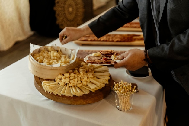 Foto vista de cerca de un hombre tomando queso de un servicio de catering durante un evento. foto de alta calidad