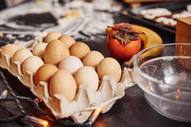 Vista de cerca de huevos, leche, frutas y otros ingredientes que están sobre la mesa.