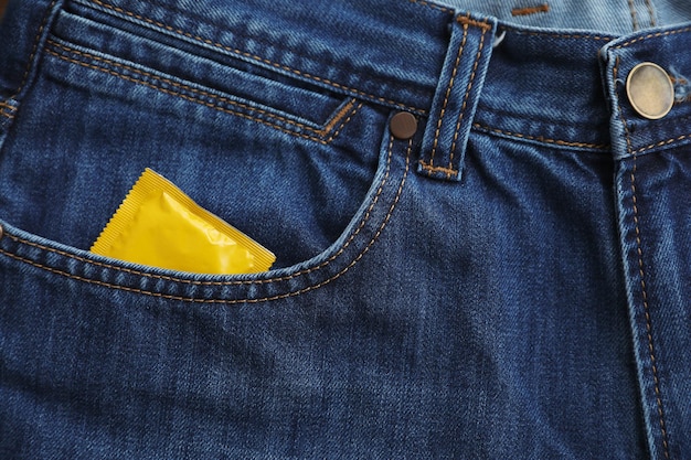 Vista de cerca de jeans con condón en el bolsillo Concepto de sexo seguro