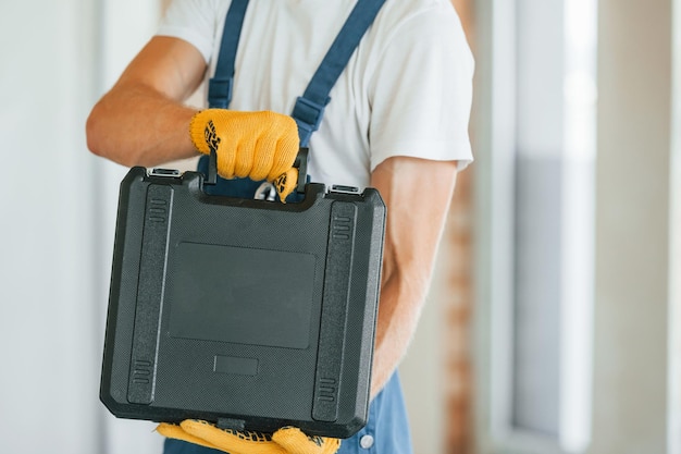 Vista de cerca Joven trabajando en uniforme en la construcción durante el día