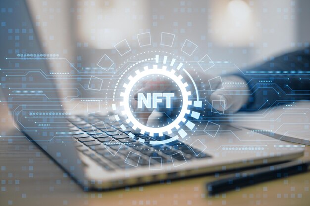 Vista de cerca y lateral de la mano masculina usando una computadora portátil con holograma nft redondo creativo en un fondo borroso Concepto de obra de arte de token no fungible y blockchain digital Exposición doble
