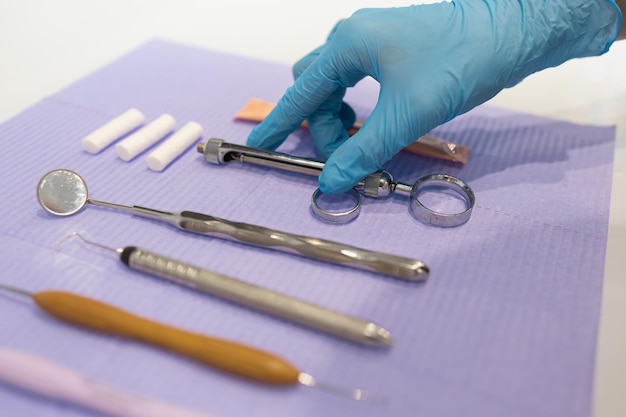 Vista de cerca de la mano del dentista toma una jeringa de carpool