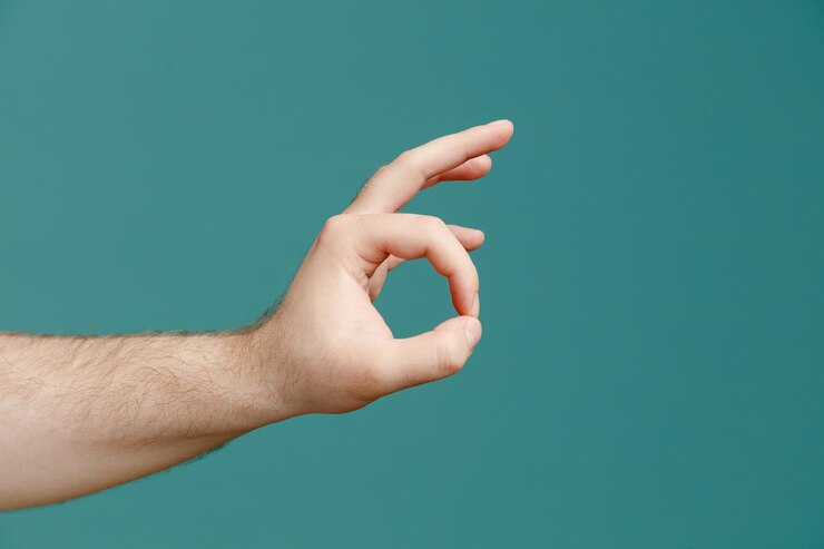 Foto vista de cerca de la mano masculina joven que muestra el signo ok aislado sobre fondo azul