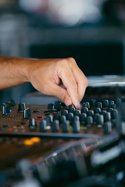 Vista de cerca de las manos de un DJ tocando el mezclador mientras actúa en un festival de música de alta calidad