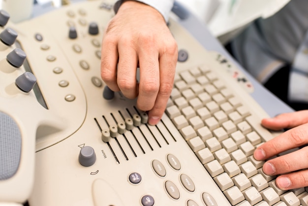 Vista de cerca en las manos de los médicos que trabajan en el teclado de ultrasonidos