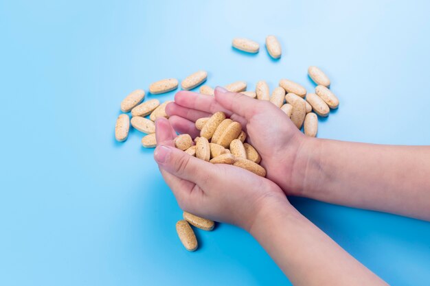 Vista de cerca de las manos del niño con pastillas, el niño pequeño juega solo con pastillas pastillas en casa.