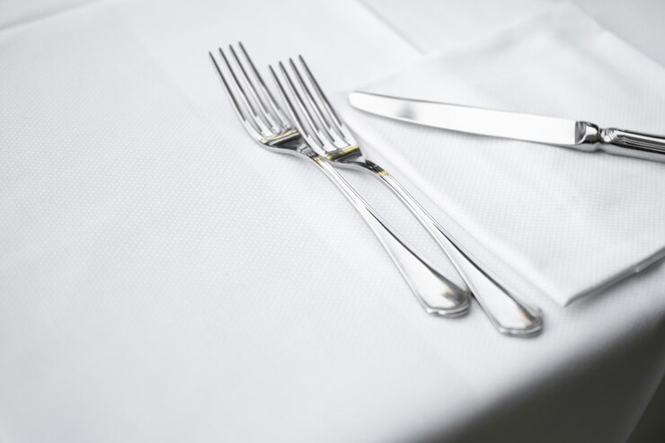 Vista de cerca del mantel de cubiertos y la servilleta de una elegante mesa de restaurante