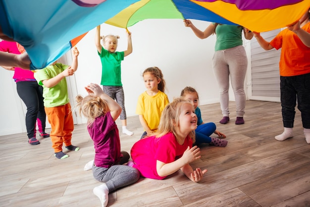 Vista de cerca de los niños bajo una enorme cubierta de arco iris