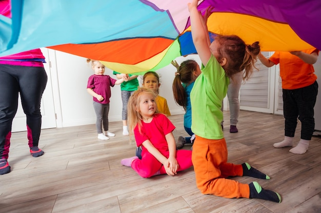 Vista de cerca de los niños bajo una enorme cubierta de arco iris