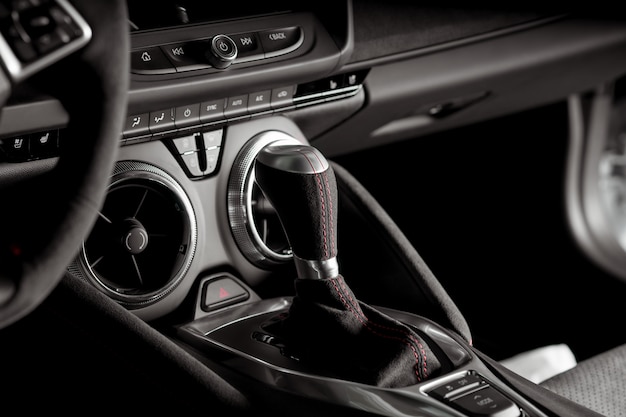 Vista de cerca de la palanca de cambios automática dentro de un coche deportivo, en blanco y negro