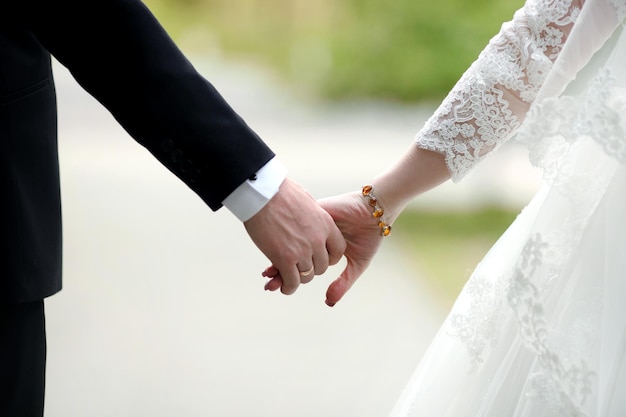 Vista de cerca de la pareja casada cogidos de la mano