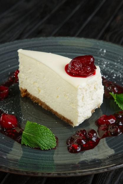 Vista de cerca del pastel de queso decorado con cereza, fresa y frambuesa