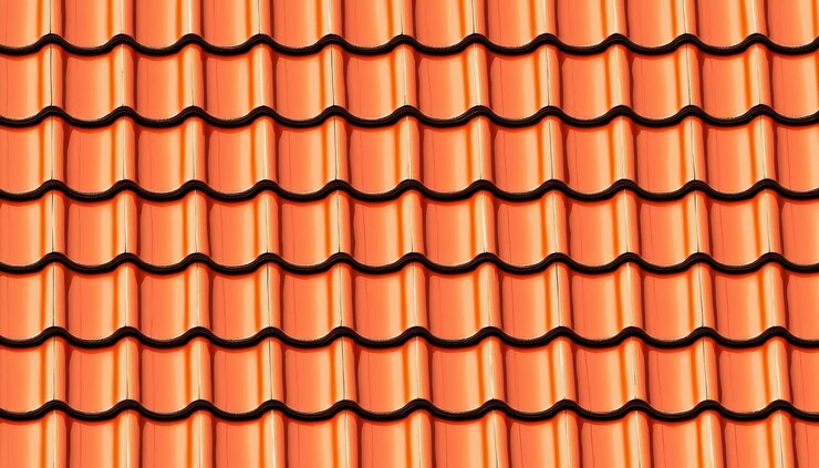 Una vista de cerca de un patrón de baldosas de techo naranja texturizado que muestra el diseño ondulado y la disposición uniforme