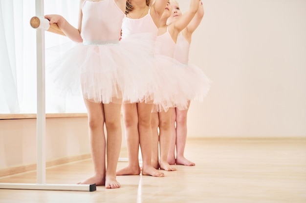 Vista de cerca Pequeñas bailarinas preparándose para la actuación practicando movimientos de baile