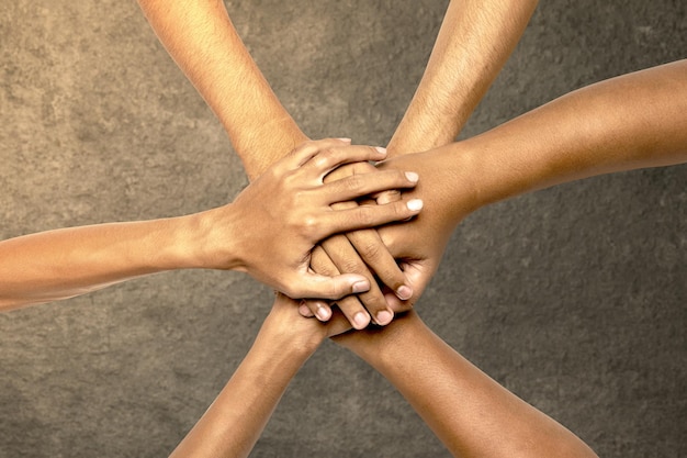 Foto vista de cerca de personas apilando sus manos para la unidad y el trabajo en equipo