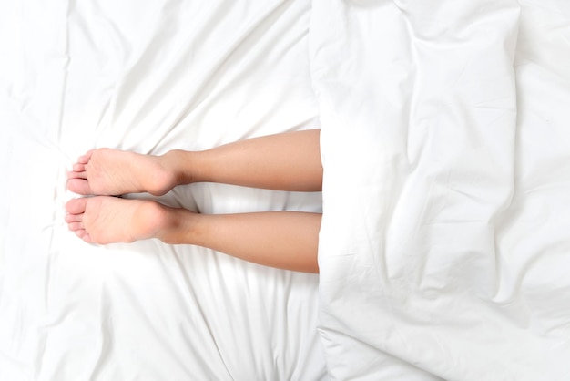 Vista de cerca de las piernas de una mujer en una cama