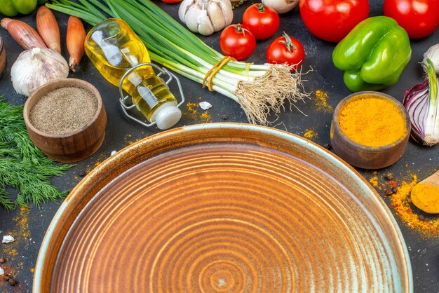 Vista de cerca de la placa azul y verduras frescas especias paquete verde sobre mesa negra