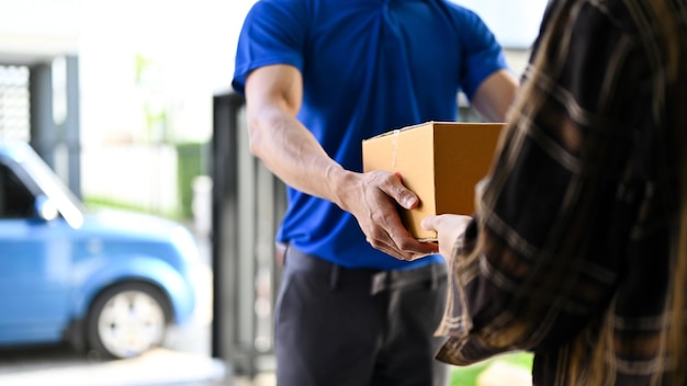 Foto vista de cerca del repartidor entregando el paquete al cliente mientras está parado frente a su camioneta