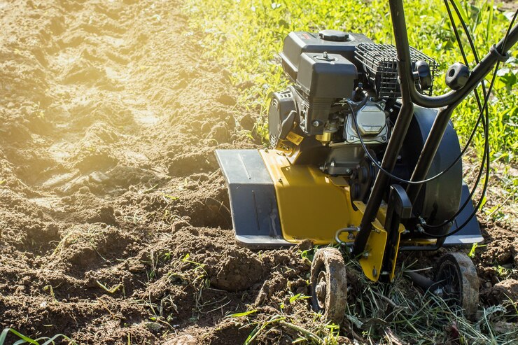 Una vista de cerca sobre el motor cultivador durante el proceso de arado de la temporada de primavera concepto de obras de jardinería