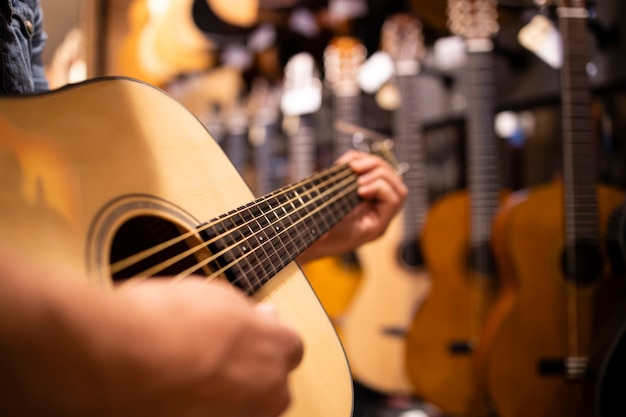 Vista de cerca del talentoso músico tocando la guitarra en la tienda de música.