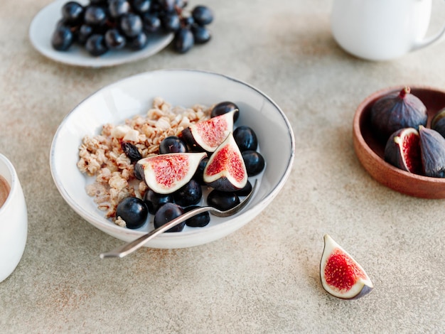 Vista de cerca de un tazón de desayuno con uva azul de granola y rodajas de higo Alimentación vegana saludable