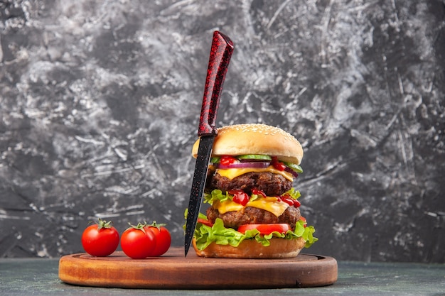 Vista de cerca de tomates sándwich caseros sobre una tabla de cortar de madera sobre una superficie de color oscuro con espacio libre