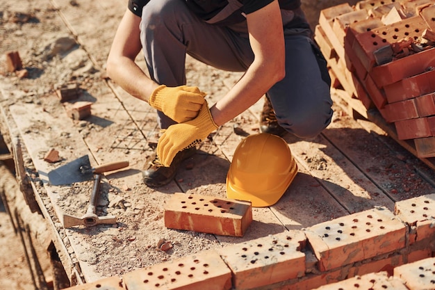 Vista de cerca del trabajador de la construcción en uniforme y equipo de seguridad preparándose para el trabajo